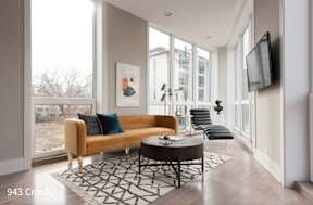 a living room with a large window and a couch and a table