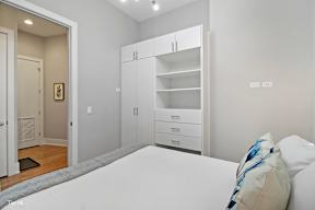 a bedroom with a bed and a bookcase in front of it