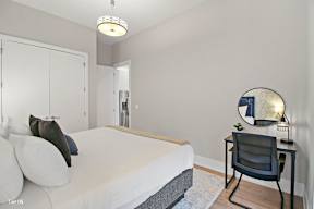 a bedroom with a bed and a desk with a chair
