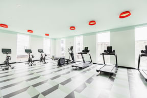 a fitness room with exercise equipment on a checkered floor
