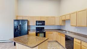 A kitchen with wooden cabinets and granite countertops.