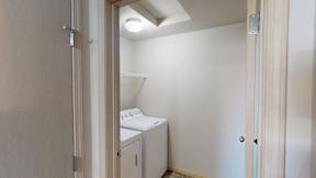 A small room with a washing machine and a door.