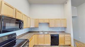 A kitchen with wooden cabinets and a black stove top oven.