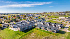 A bird's eye view of a residential area with houses and green lawns.