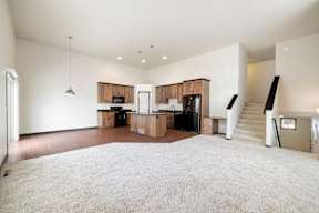 A spacious living room with a staircase leading to the upper floor.