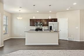 A kitchen with a white counter and brown cabinets.
