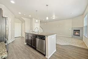 A modern kitchen with a wood floor and stainless steel appliances.