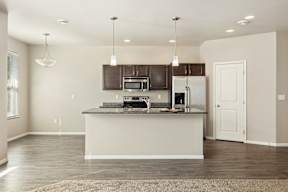 A kitchen with a white island and dark brown cabinets.