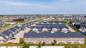 A large housing complex with multiple buildings and a parking lot.