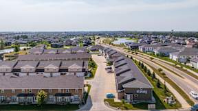 A bird's eye view of a residential area with houses and a road.