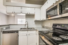 a kitchen with white cabinets and black appliances