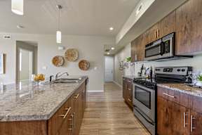 A modern kitchen with wooden cabinets and a granite countertop.
