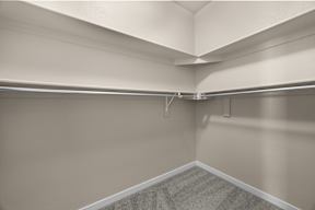 A room with a grey carpet and white walls.