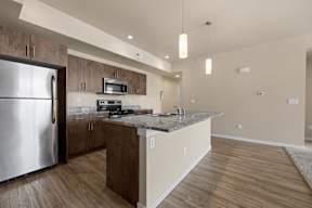 A modern kitchen with a stainless steel refrigerator and wooden cabinets.