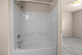 A white bathroom with a bathtub and a shower.