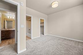 A spacious room with a carpeted floor and a ceiling light.