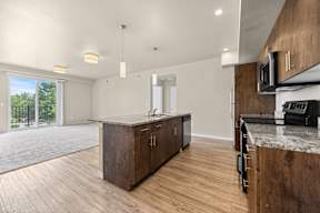 A kitchen with wooden cabinets and a marble countertop.
