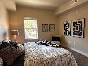 A bedroom with a large bed and a window.