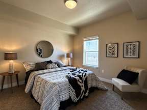 A bedroom with two beds and a chair.