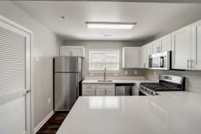 a kitchen with stainless steel appliances and white counter tops