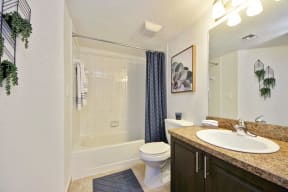 Bathroom with sink, cabinets, toilet, mirror, and tub shower