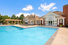 Apartments in Naperville, IL, for Rent - 803 Corday at Naperville - Resort-Style Swimming Pool with Lounge Chairs, BBQ Area, and Building.