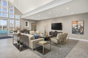 Two-Bedroom apartments in Naperville, IL - 803 Corday at Naperville - Community Room With Flat Screen TV, Couch, Lounge Chairs, Rug, Coffee Table, And Accent Table.