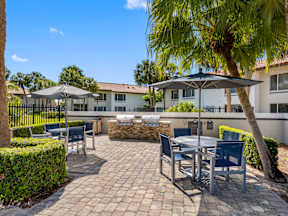 A patio with a table and chairs under an umbrella.