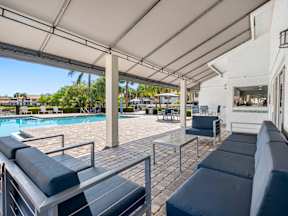 A poolside area with a white building in the background.