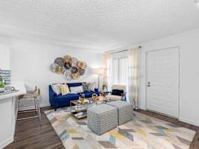 A living room with a blue couch and a wooden coffee table.