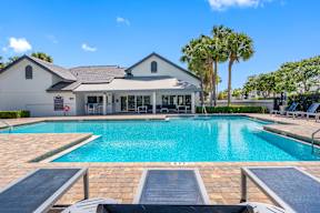 A large swimming pool in front of a house.