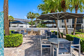A patio with a table and chairs under an umbrella.