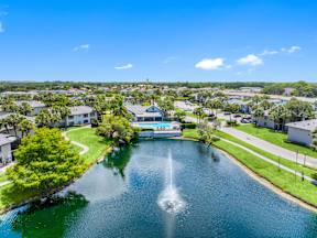 A fountain in the middle of a lake in a residential area.