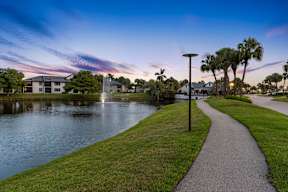 A serene park with a water feature and a walking path.