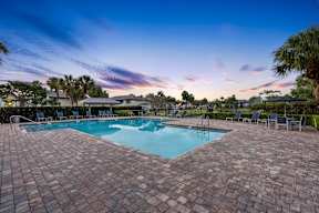 A swimming pool surrounded by a brick patio.