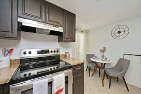 Eat-in kitchen with small table with two chairs and stainless steel oven
