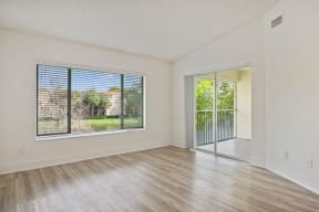 an empty living room with a sliding glass door to a patio