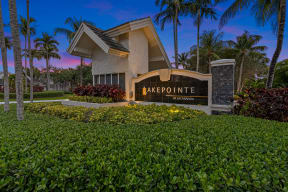 a building with a sign that reads lake pointe in front of palm trees