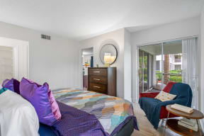 a bedroom with a bed and a couch and a window