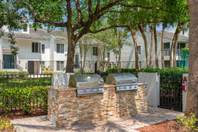 two stainless steel barbecue grills in front of an apartment building