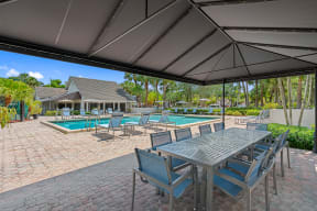 a patio with a table and chairs and a swimming pool