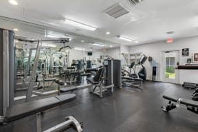 a gym with weights and cardio equipment on the floor and mirrors