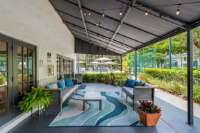 a patio with couches and tables and windows
