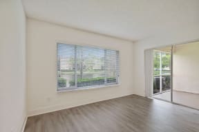 Living room with vinyl flooring, large window and balcony door
