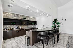 A modern kitchen with dark wood cabinets and a bar area.