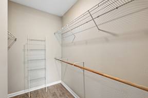 A walk-in closet with a metal rod and shelves.