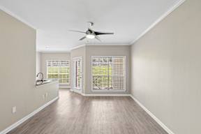 A room with a ceiling fan and a window with blinds.