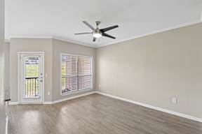 A room with a ceiling fan and a window with blinds.
