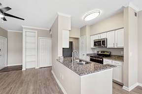 A kitchen with a granite countertop and white cabinets.