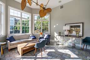 A living room with a couch, chair, and a fan.
